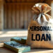 A burlap sack labeled "PERSONAL LOAN" sits on the floor of a partially constructed wooden house. Surrounding the sack are stacks of U.S. dollar bills, suggesting a loan or financial support for home construction from TraceLoans.com Personal Loans. Sunlight streams through the windows. | TraceLoans